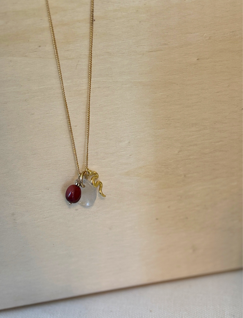 Gold chain necklace with red stone, clear crystal and brass snake charms