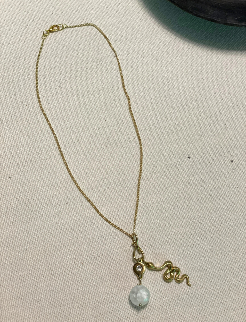 Gold chain necklace with selenite crystal and brass snake charms, alternate view